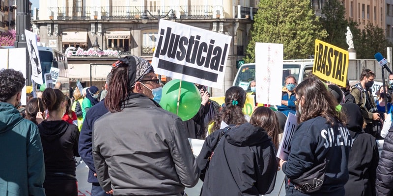 Um grupo de manifestantes segura cartazes e pede justiça nas ruas