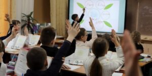 Los estudiantes en el aula levantan las manos porque han logrado un aprendizaje significativo.