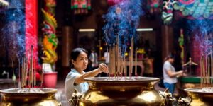 Una mujer enciende incienso en un templo taoísta.